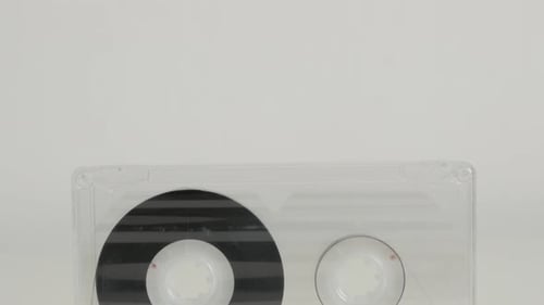 Old analogue magnetic audio tape on white 4K 2160p 30fps UltraHD tilting footage - Close-up of retr