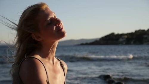 Caucasian woman relaxing by the sea 1080p FullHD footage - Beautiful self-confident blonde on the b