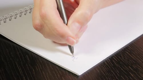 Close Up Hand Writing Valentine's Day on Notepad