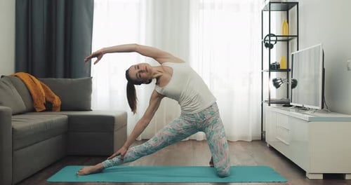 Young Woman Exercising Indoors on Yoga Mat