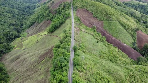 Luftaufnahme eines Autos, das mit einer Drohne auf der Bergstraße durch den tropischen Wald auf dem Land fährt