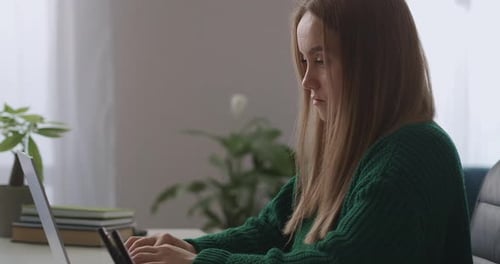 Woman Typing on a Laptop in her Home