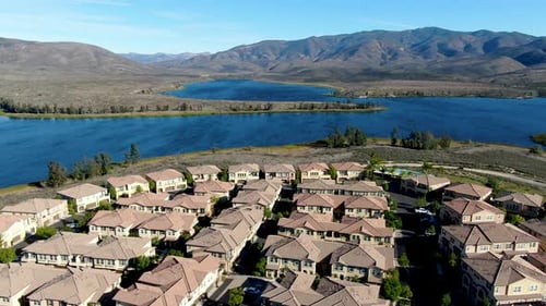 Vista aérea de un condominio residencial idéntico con un gran lago y una montaña en el fondo
