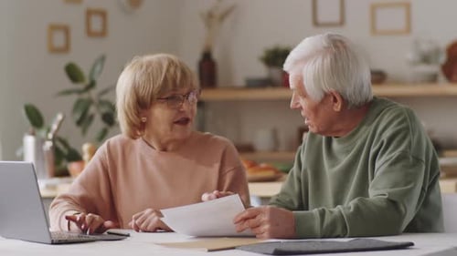 Senior Couple Reviewing Finances at Home with Laptop