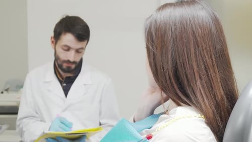 Woman with Toothache Looking to the Camera Sitting in Dental Chair