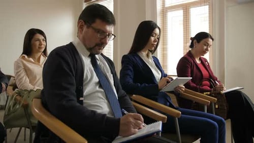 Diverse Audience Listens Attentively During Corporate Meeting