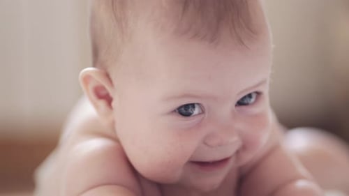 Adorable Infant Lying on Stomach, Smiling Happily