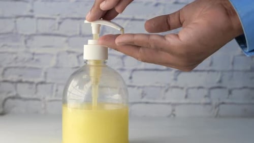 Close Up of Young Man Hand Using Sanitizer Gel for Preventing Virus