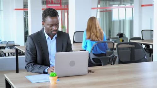 Afroamerikanischer Manager arbeitet im Open-Space-Büroangestellten in Start-up-Unternehmen