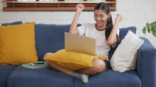 Happy Young Woman Celebrating Success on Laptop