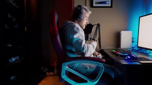 Gamer with Microphone Playing Computer Game