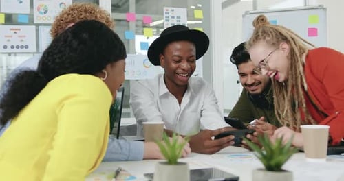 Smiling Team Gathers Around Smartphone in Office