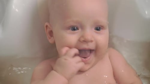 Charming Blond Infant in Bathtub Smiling