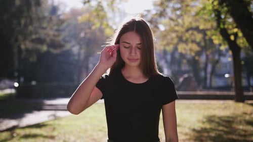 An Attractive Young Lady Using a Phone in Town. Medium Shot