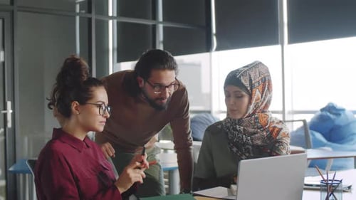 Diverse Team Collaborating on Project in Modern Office