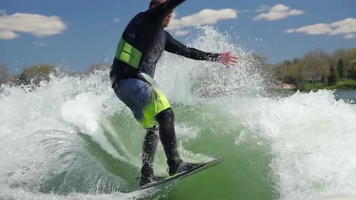 A man wake surfing behind a boat on a lake