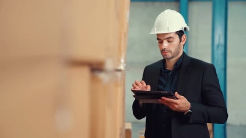 Factory Manager Using Tablet Computer in Warehouse or Factory