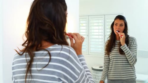 Woman Brushing Teeth in Bright Modern Bathroom