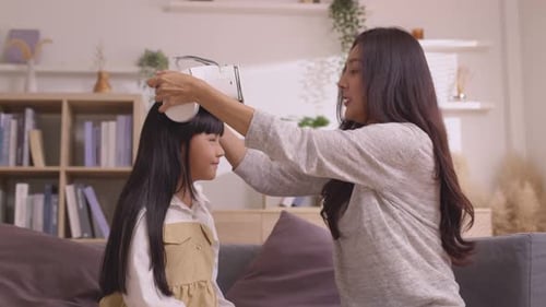 Woman Helping Girl Use Virtual Reality Headset