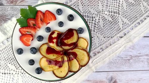 Pancakes with Strawberries and Blueberries on Table