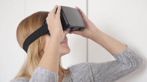 Blonde woman slow motion in white space trying virtual reality glasses 1080p HD footage - Blond fem