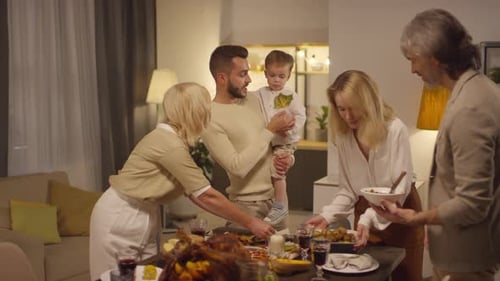 Family Gathered Around Table Preparing Festive Dinner