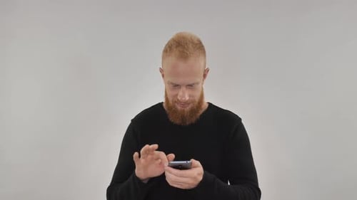 Smiling Man Using Smartphone Device Indoors