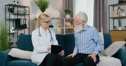 Doctor Consulting with Senior Man in Home Living Room