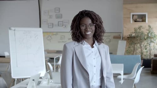 Smiling Woman Stands in Bright Modern Office