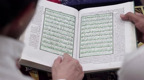 Adults Reading Islamic Book Together at Home