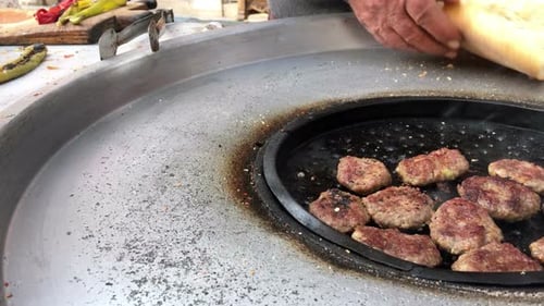 Meat Patties and Bread Cooking on Metal Grill