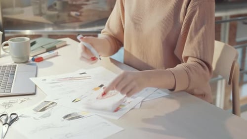 Fashion Designer Sketching at Workplace Desk