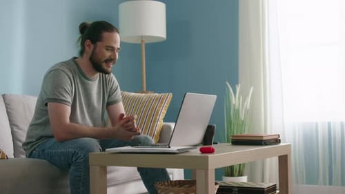 Man Talking on Laptop Computer at Home