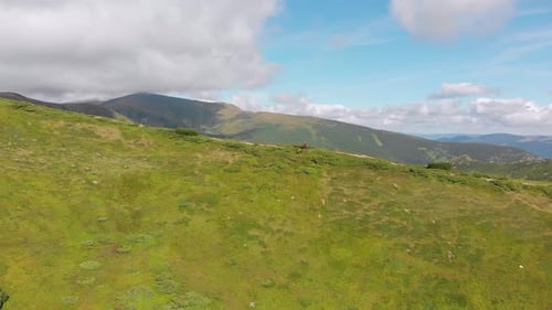 Aerial View of a Traveler with Backpack Climbing Along Mountain Slope. Epic Shot