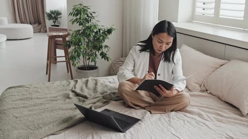 Frau macht Papierkram auf dem Bett