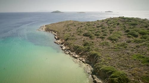 Aerial view of an empty small beach with turquoise water and stones in Greece.
