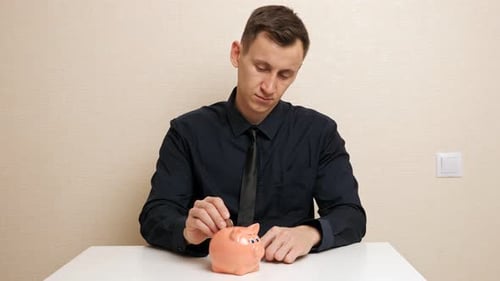 Man Hand Holds Bronze Coins and Throws Into Piggy Bank Slot