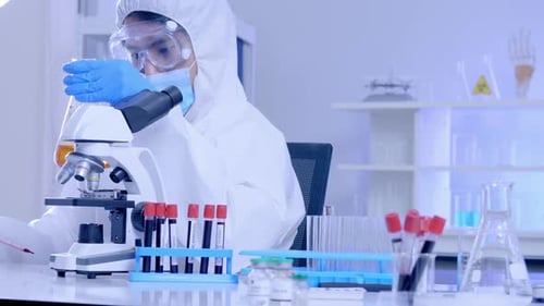 Scientist Works with Microscope in Bright Lab