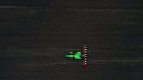 Aerial View of a Modern Green Tractor Seeding Agricultural Field