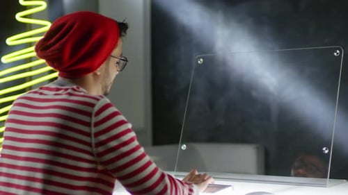 Hombre sentado en el monitor interactivo multitáctil