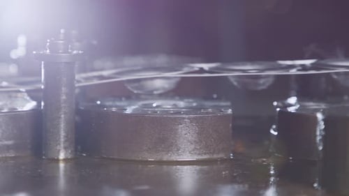 Close up of a punch press forming metal parts in a production line