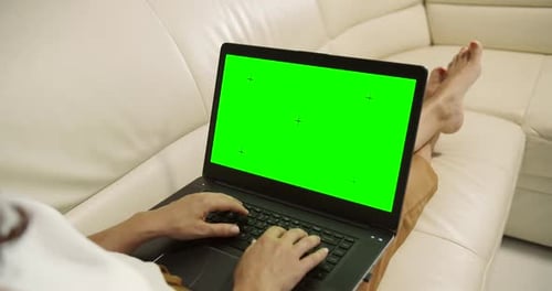 Woman Typing on Laptop with Green Screen at Home