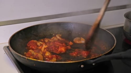Tomatoes and Garlic Sauce is Fried in a Cooking Pan Close Up