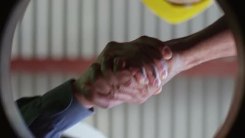 Workers Handshaking in Agreement Industrial Workplace