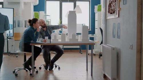 Workmates Looking at Building Model to Design Architectural Blueprints