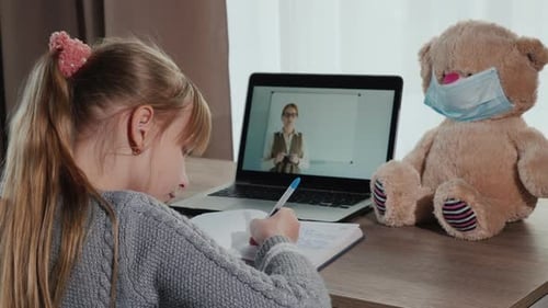 Back View A Child Listens to an Online Lesson at Home