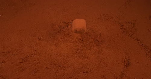 Chocolate Truffle falling on Chocolate Powder, slow motion 4K
