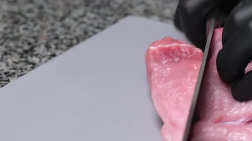 Slicing Raw Meat on a Cutting Board