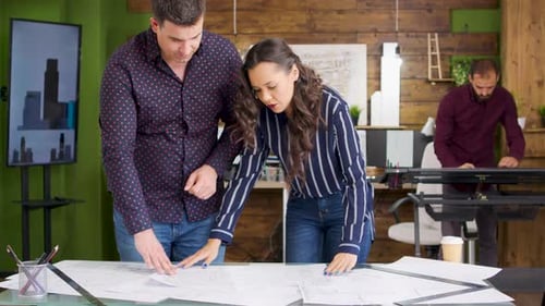 Architects Reviewing Blueprints in Bright Modern Office