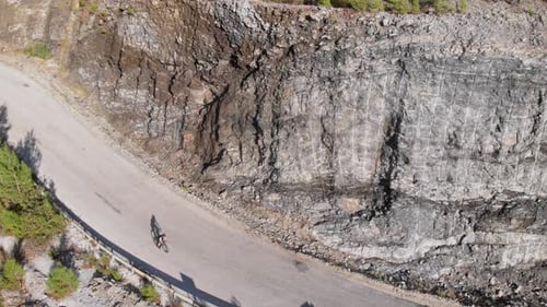 Cyclist climbing up on mountain road. Athlete on road bicycle cycling in mountains
